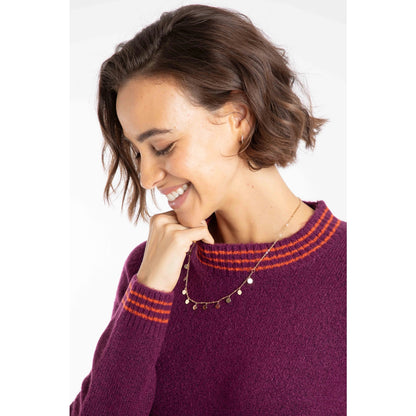 Woman wearing a Weird Fish Beet purple knitted Dawkins jumper with red stripe neck detail on a white background
