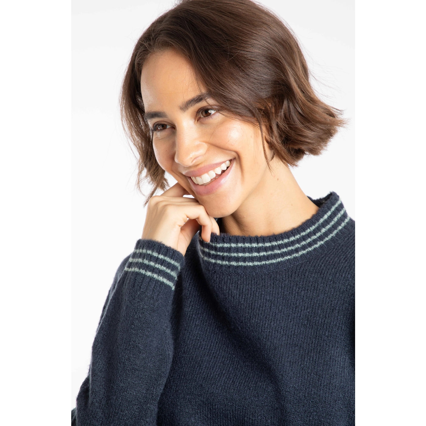 Woman wearing a Weird Fish womens Dawkins knitted jumper with stripe neckline and cuffs with a white background