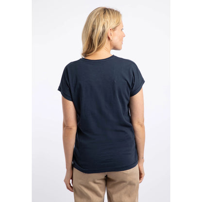 Back view of a woman wearing a Weird Fish short sleeve navy t-shirt featuring an abstract koi carp print made up of fern leaves on the front.