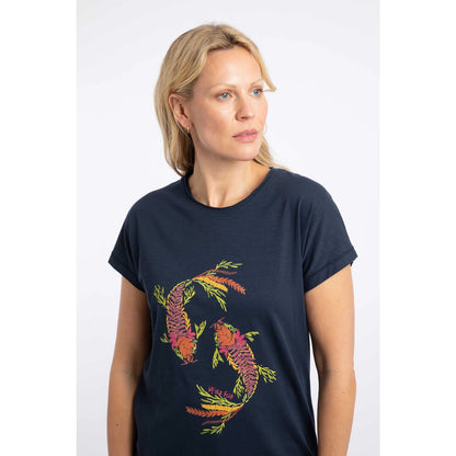 Close-up view of a woman wearing a Weird Fish short sleeve navy t-shirt featuring an abstract koi carp print made up of fern leaves on the front.