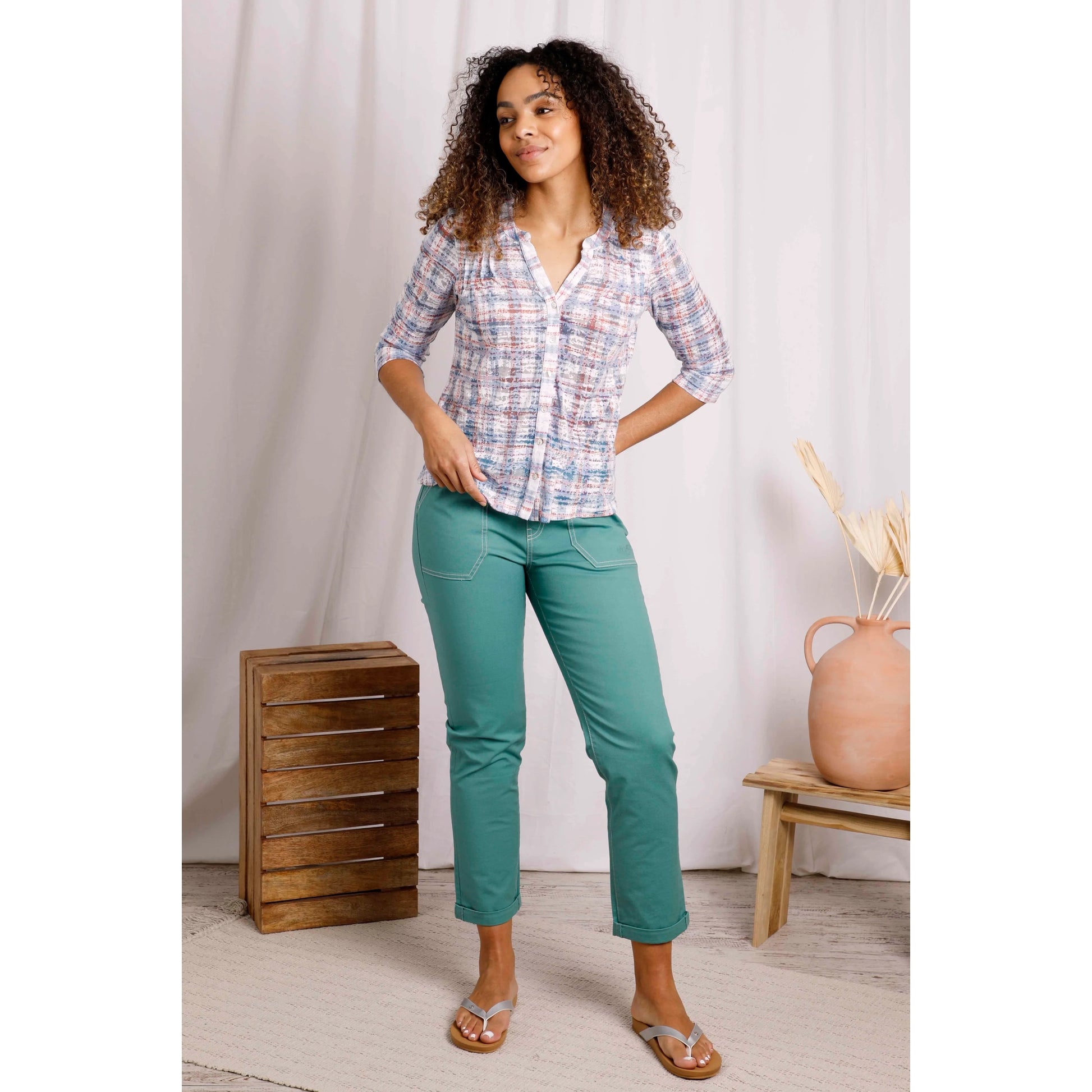 Woman wearing Weird Fish womens Fes check shirt in Pale Denim Blue with green pants and sandals in casual indoor setting