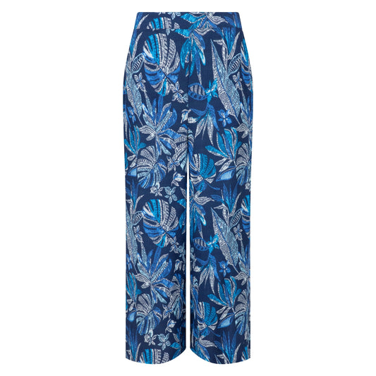 Front view of a pair of Weird Fish Sarita wide leg crinkle viscose cropped trousers in indigo blue with a tropical leaf pattern.