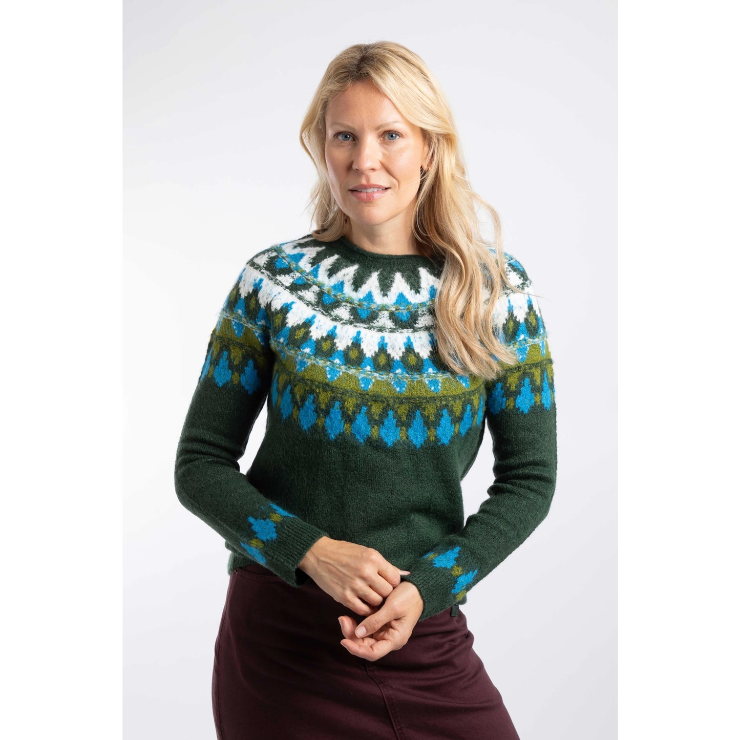 Front view of a woman wearing a Weird Fish knitted Lowell jumper in Bottle Green, with a Fair Isle pattern across the chest and shoulders.
