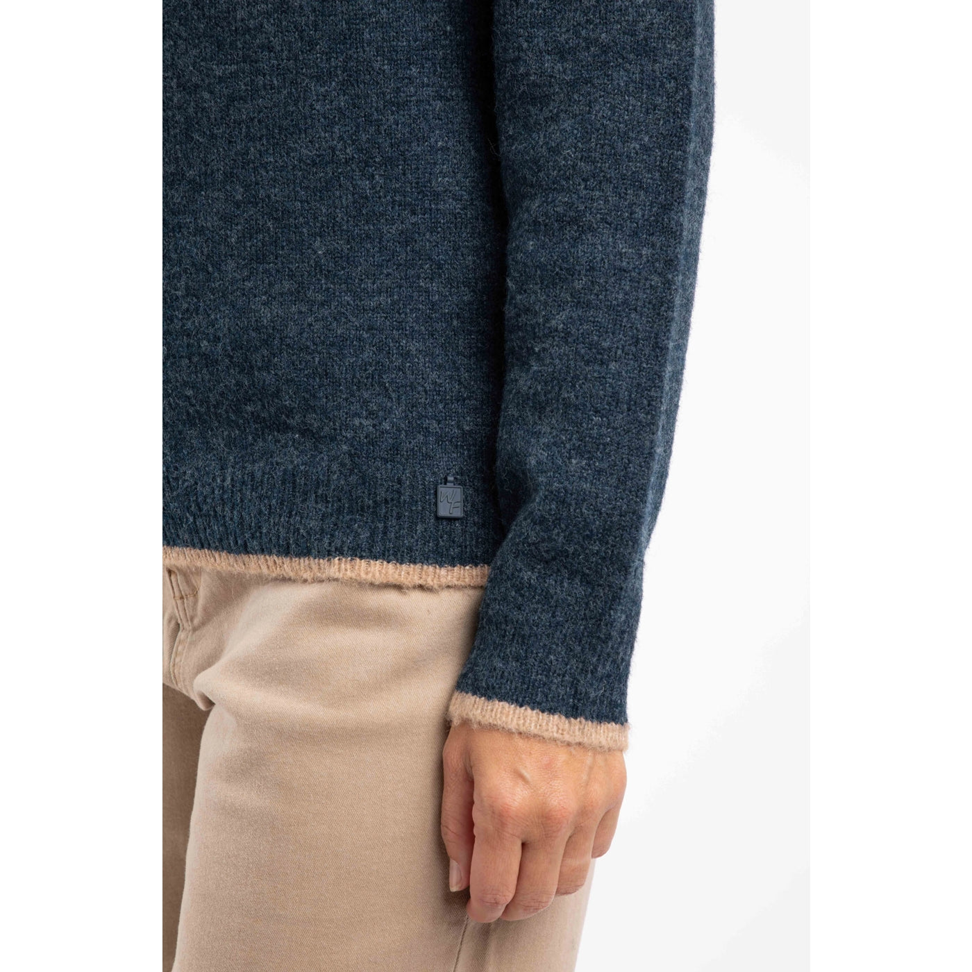 Close-up of a woman wearing a navy blue Weird Fish Miska jumper with beige trim on a white background