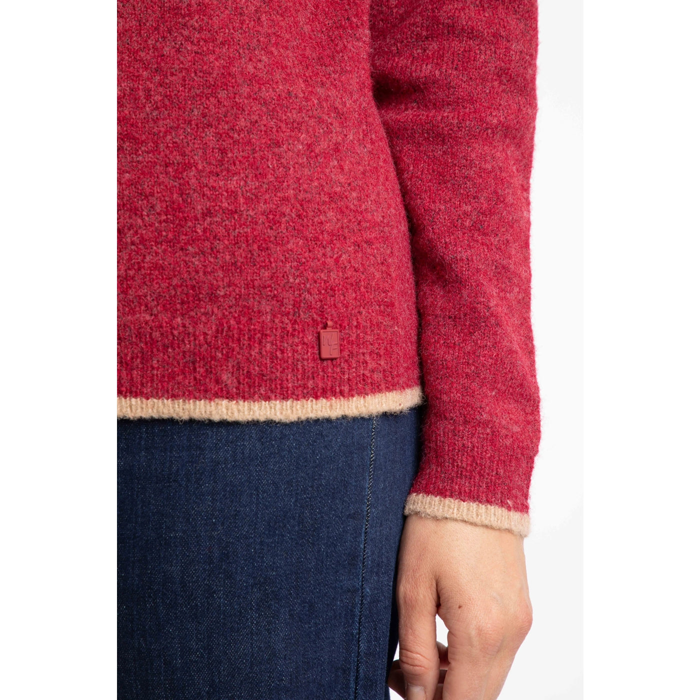 Close-up of a woman wearing a red Weird Fish Miska jumper with beige trim on a white background