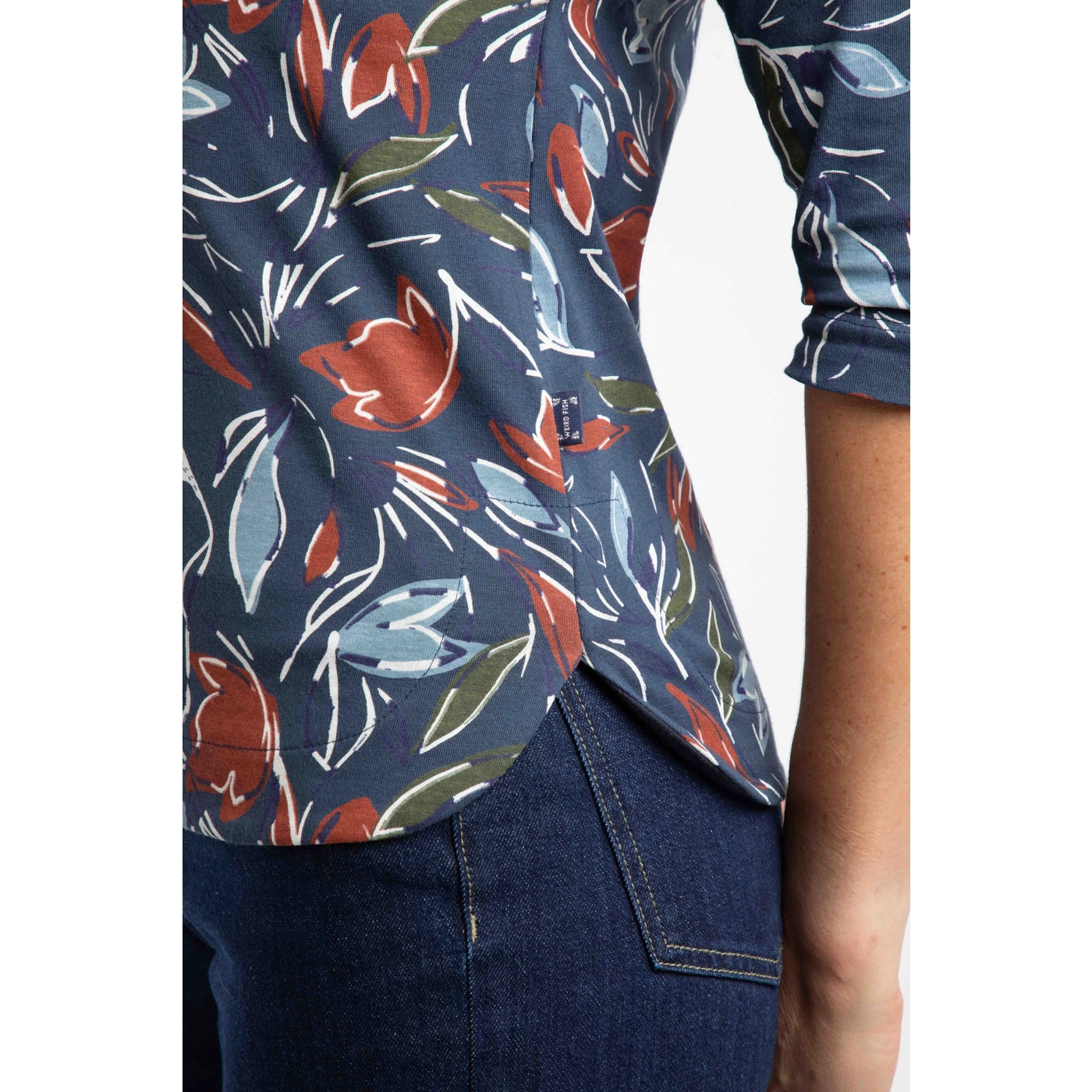 Weird Fish navy t-shirt with colourful floral pattern worn by a person on a white background