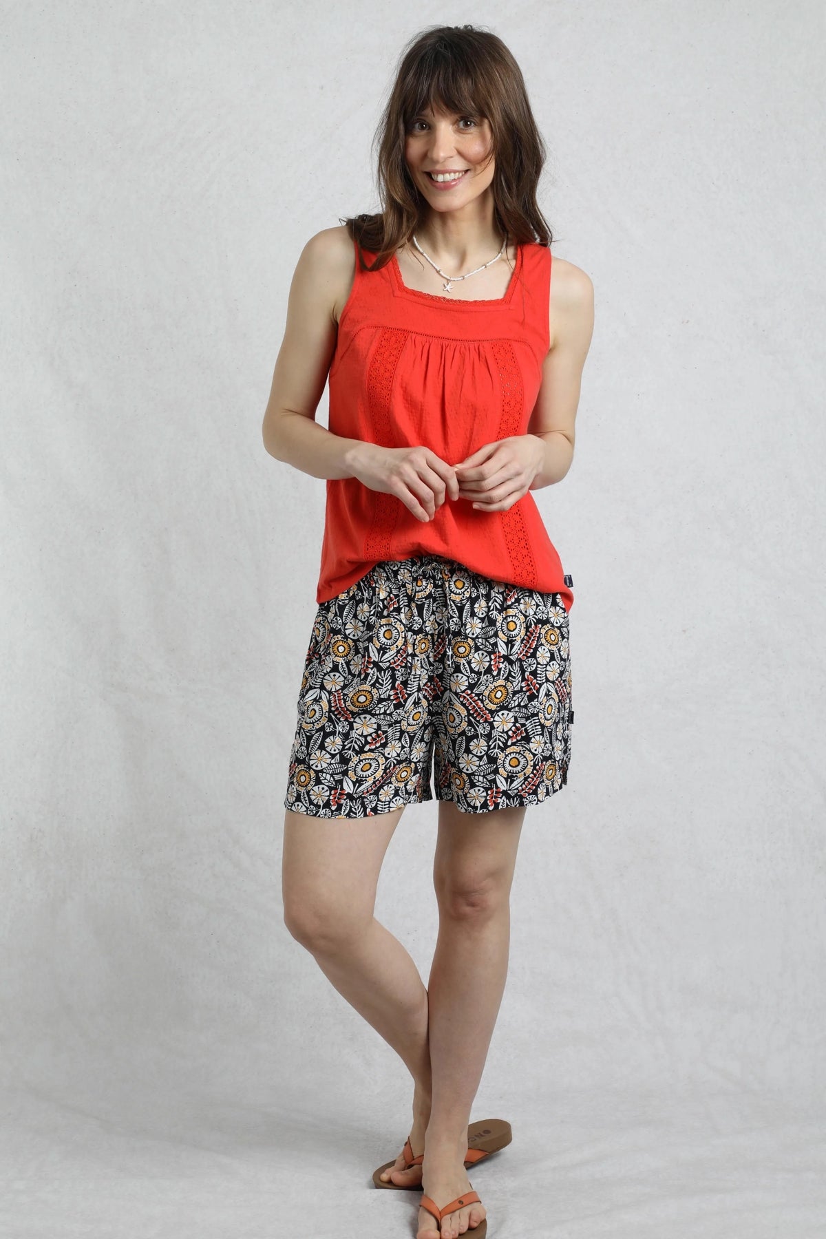 Weird Fish womens navy floral shorts worn by model with red sleeveless top and sandals