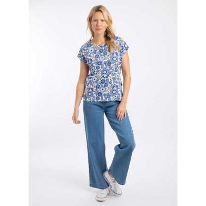 Woman wearing a blue and white floral Weird Fish Paw Paw short sleeve tee and jeans on a white background