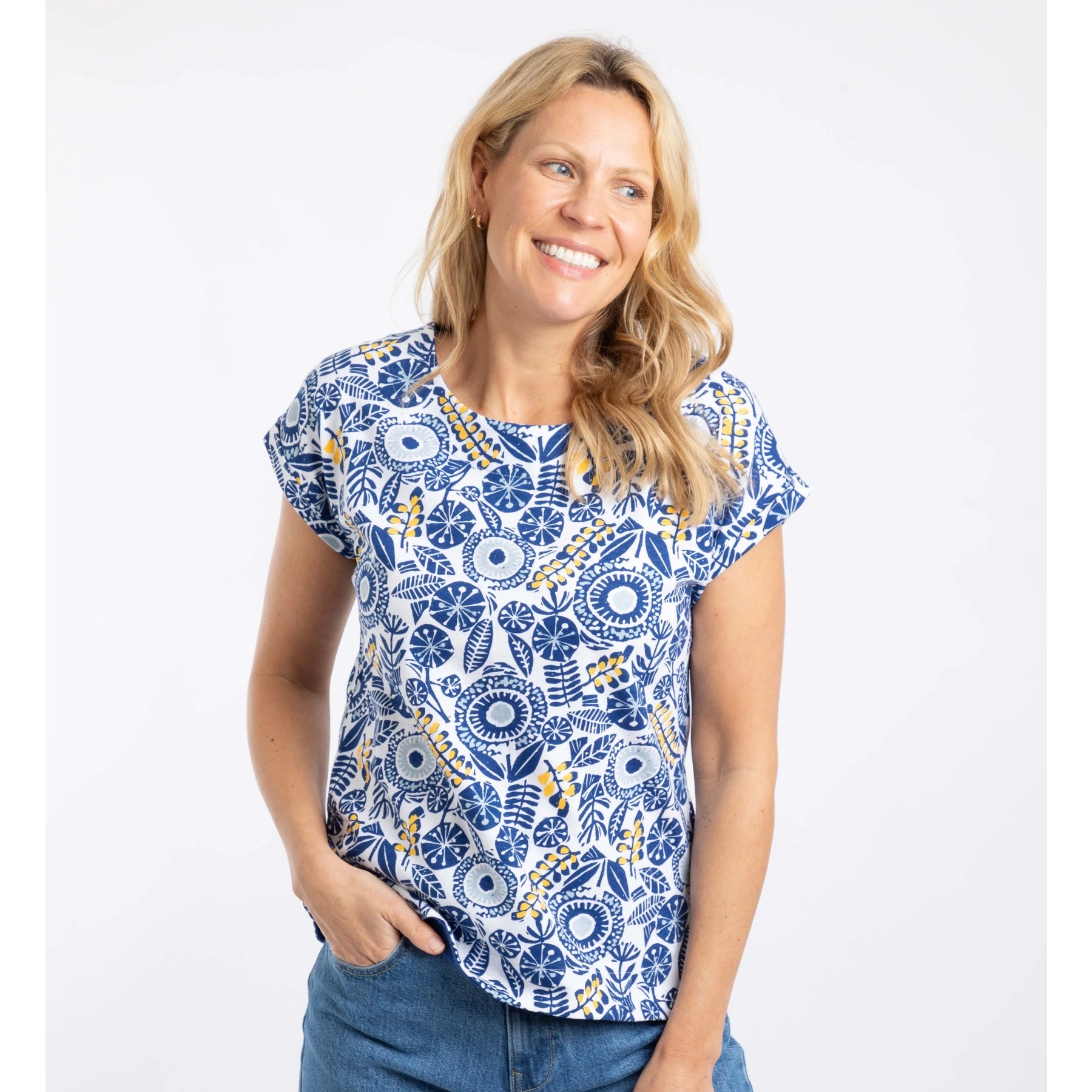 Woman wearing a blue and white floral patterned Weird Fish Paw Paw t-shirt on a white background