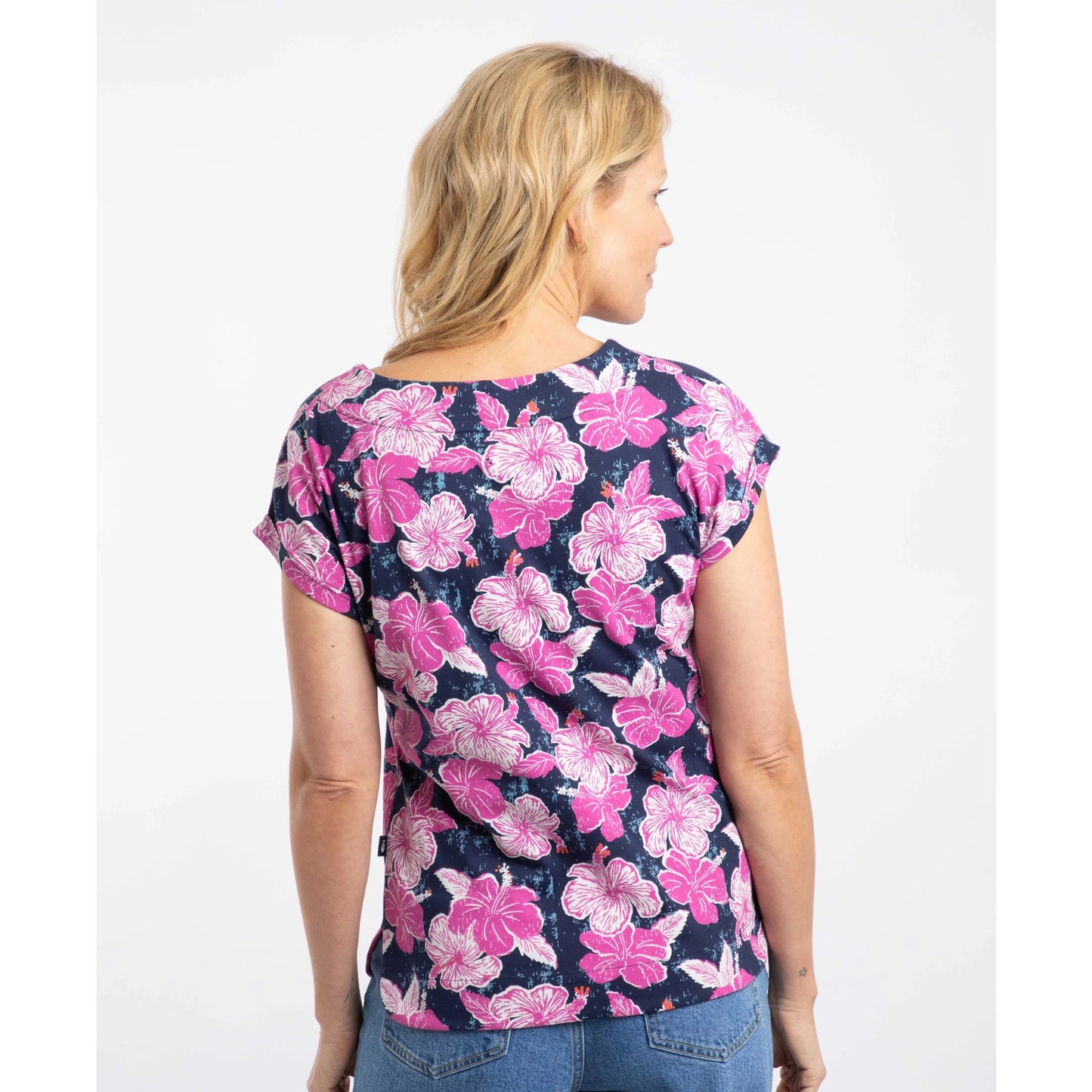 Back view of a woman wearing a short sleeve Weird Fish Paw Paw t-shirt with a pink floral print on a white background