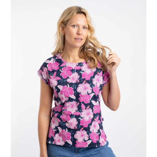 Front view of a woman wearing a short sleeve Weird Fish Paw Paw t-shirt with a vibrant Fuchsia Punch pink floral print on a white background