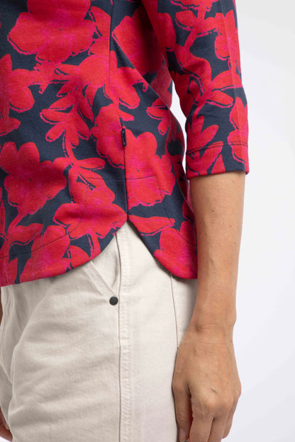 Close-up view of the curved side seam of a women's Weird Fish three-quarter sleeve Pinto t-shirt in Cranberry Red with a bold floral pattern.