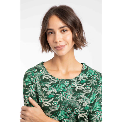 Close-up view of a woman wearing a Weird Fish three-quarter sleeve Pinto t-shirt in Laurel Green with a leafy floral pattern.