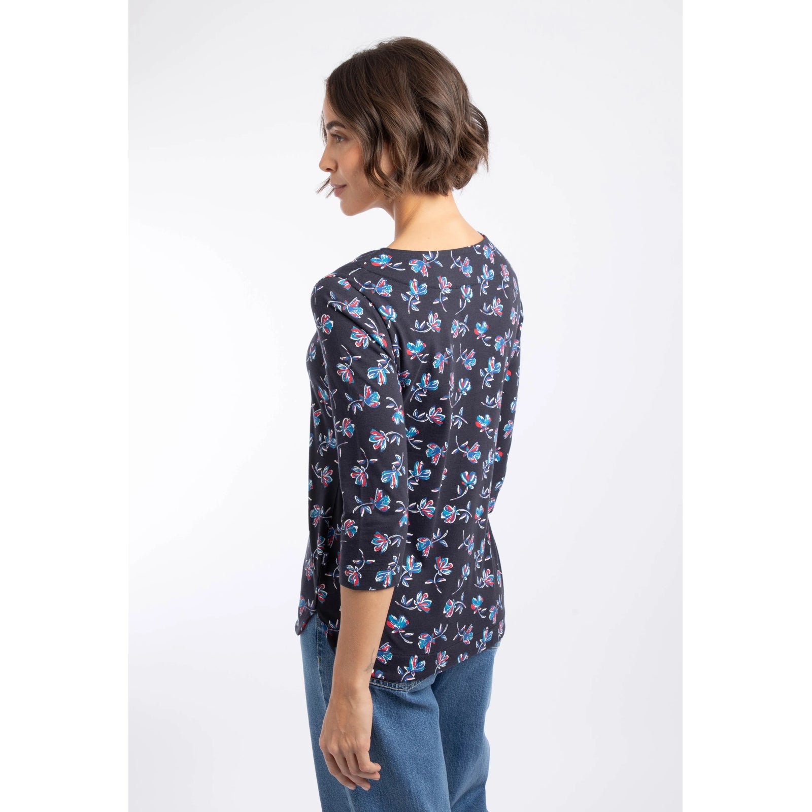 Back view of a woman wearing a Weird Fish three-quarter sleeve Pinto t-shirt in Midnight Navy with a blue and red floral pattern.