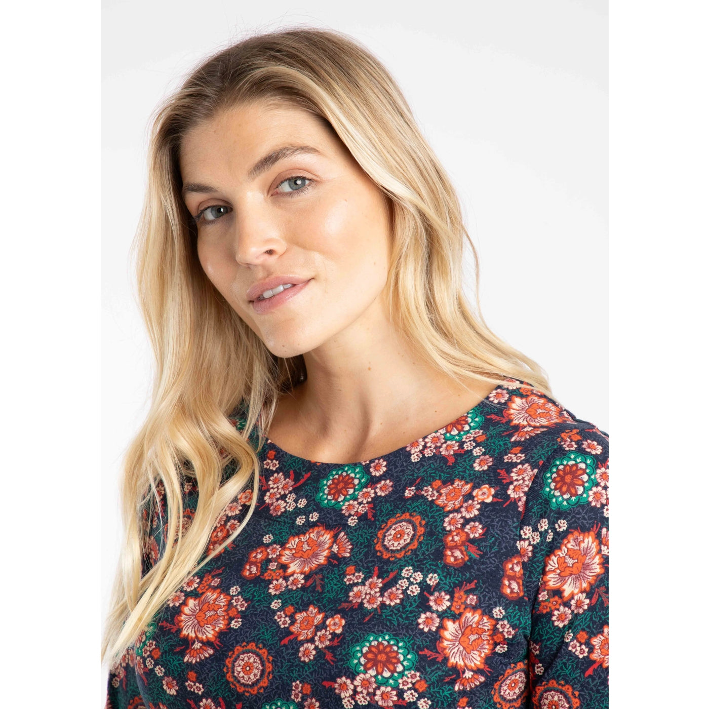 Woman wearing a floral patterned top on a white background