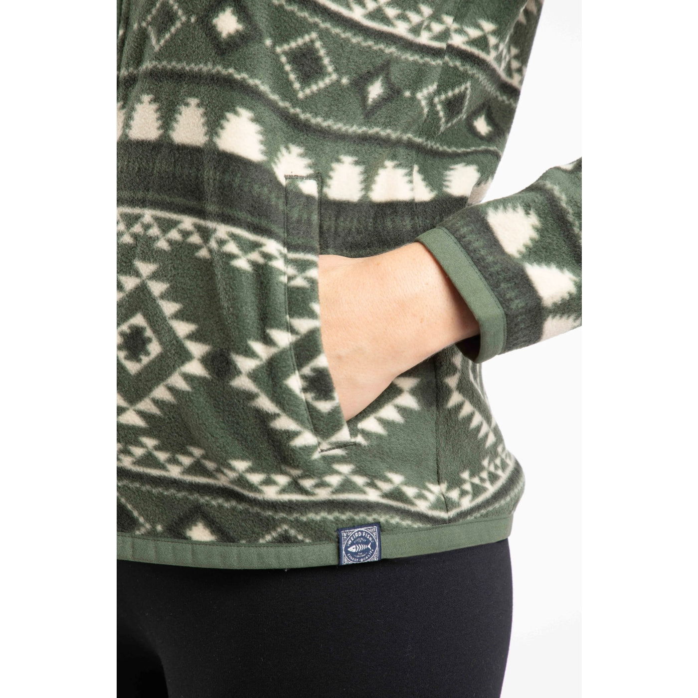 Close-up view of the tummy pockets on a women's Weird Fish full zip Rochelle fleece in Deep Lichen Green with an Aztec pattern.
