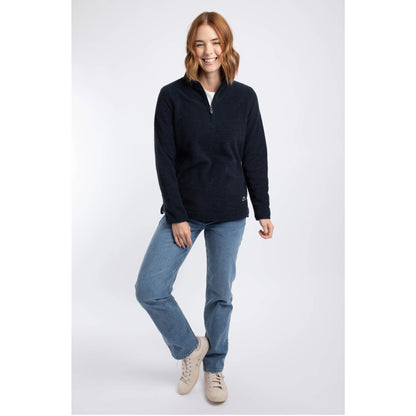 A woman wearing a Weird Fish 1/4 zip Sarah fleece in Midnight Navy with blue jeans.