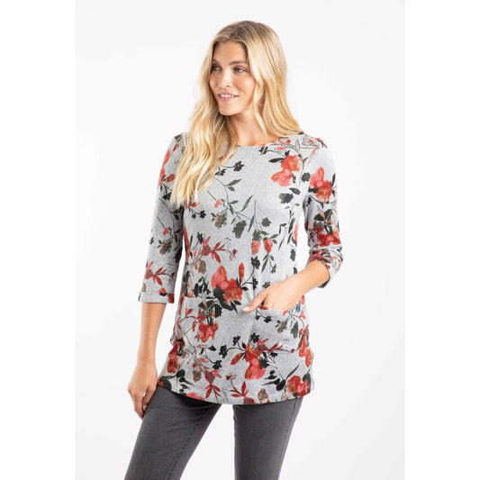 Woman wearing a Weird Fish floral print 3/4 sleeve tunic in grey with a red and green floral pattern on a white background