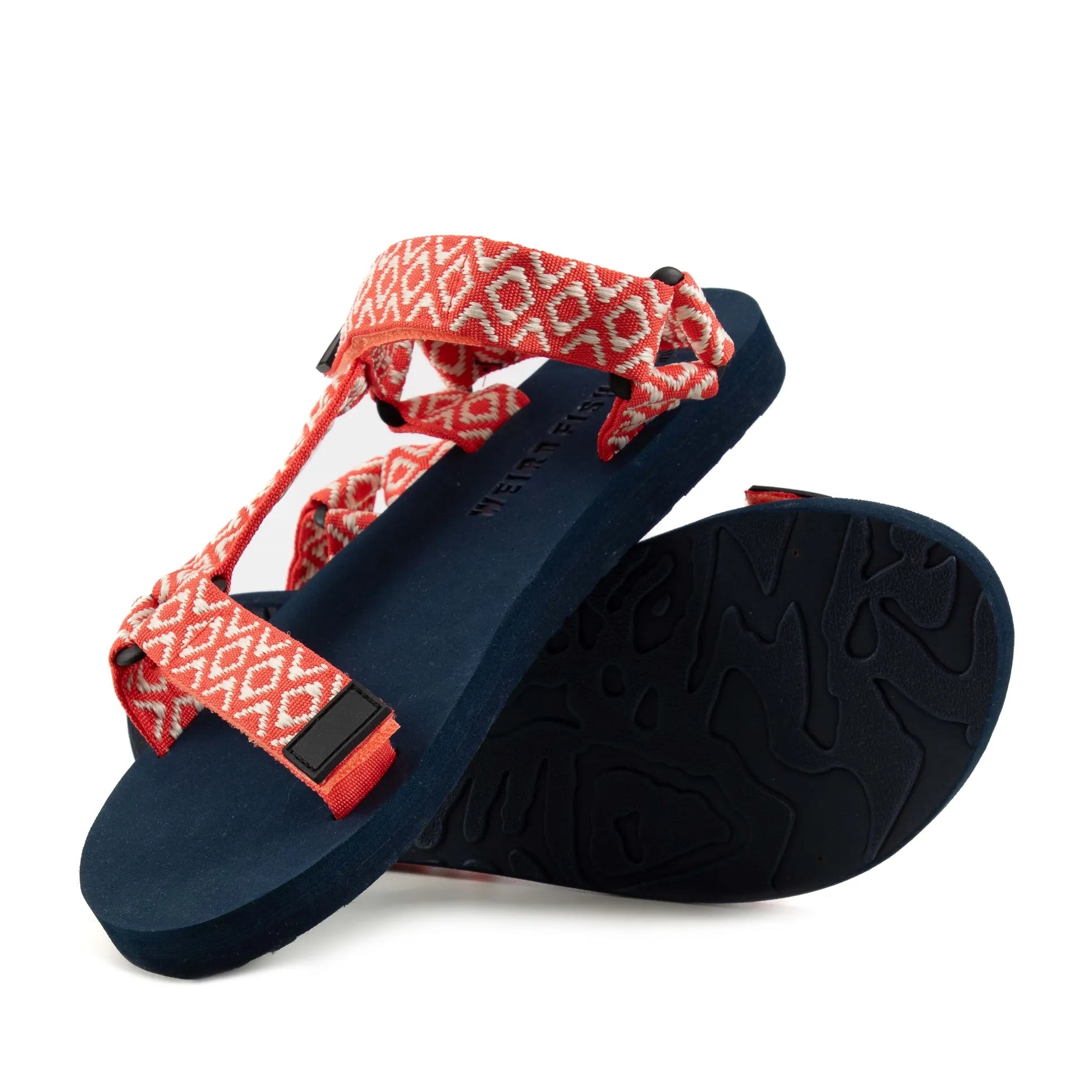 Bottom sole view of a womens Weird Fish Trek webbing velcro strap sandal in coral with an Aztec style pattern.
