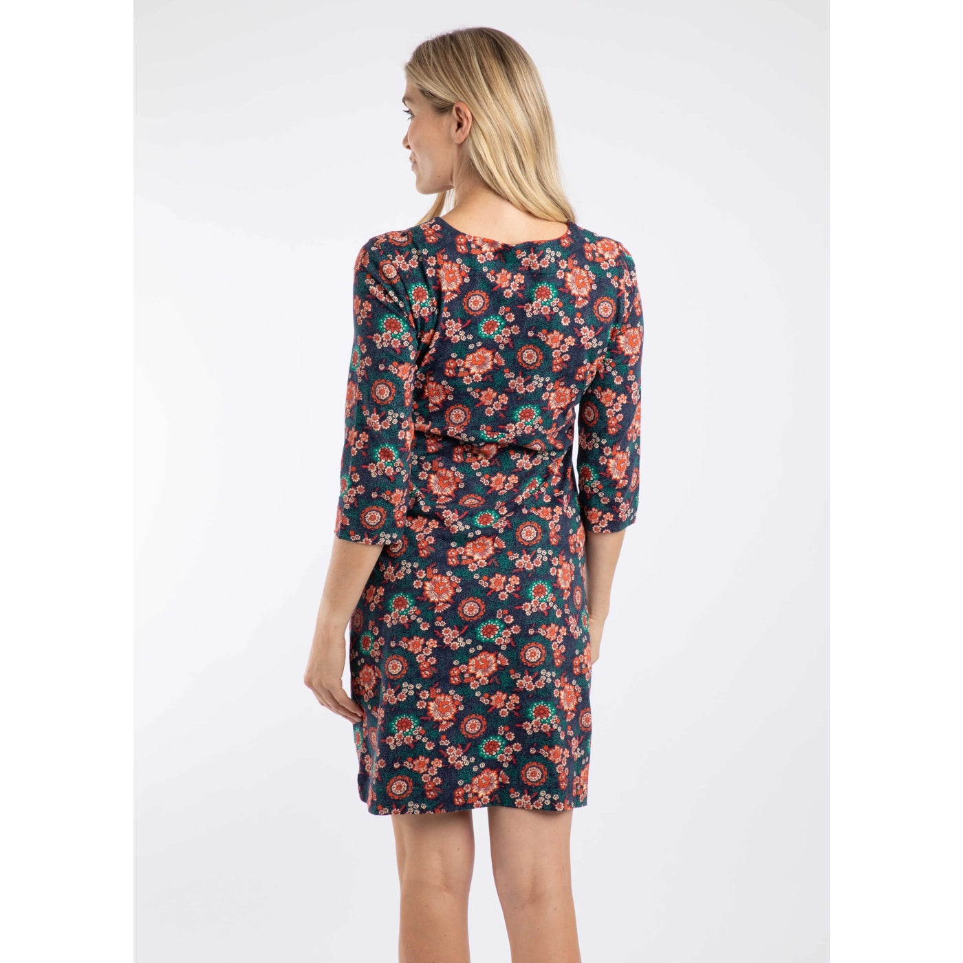 Woman wearing a Weird Fish blue and coral 3/4 sleeve Starshine floral dress on a white background