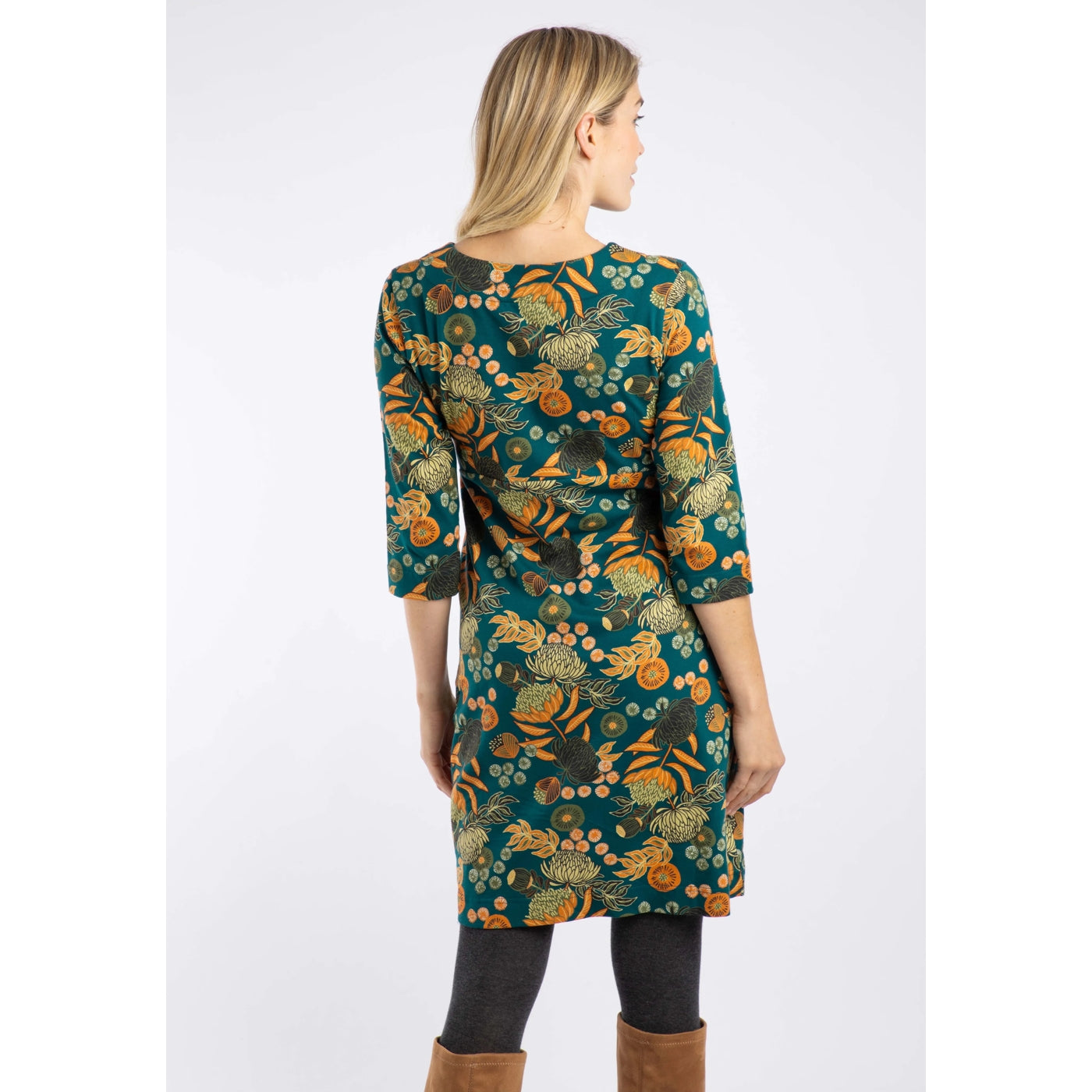 Woman wearing a Weird Fish Starshine Deep Teal floral patterned dress on a white background