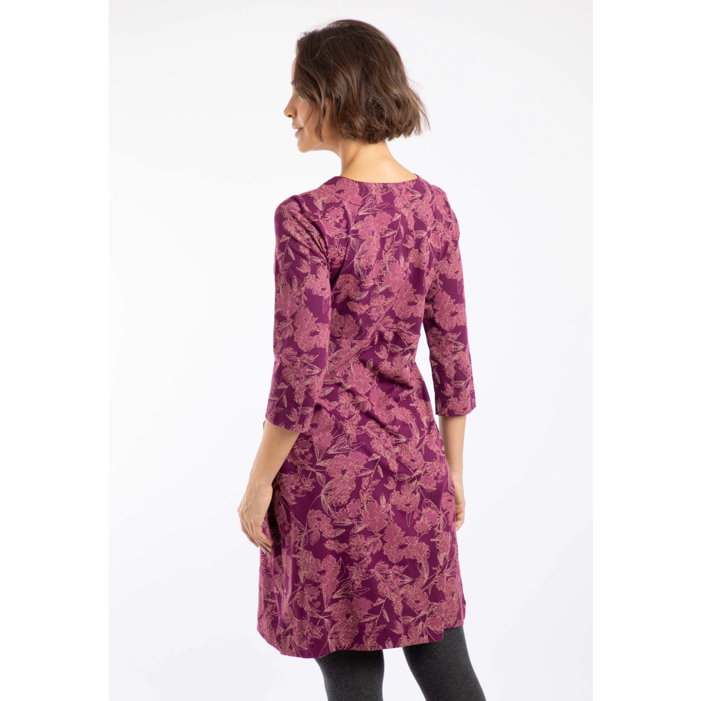 Woman wearing a purple floral patterned Weird Fish Starshine dress on a white background