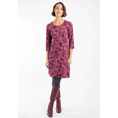 Woman wearing a Weird Fish Plum purple floral patterned Starshine dress with long sleeves on a white background