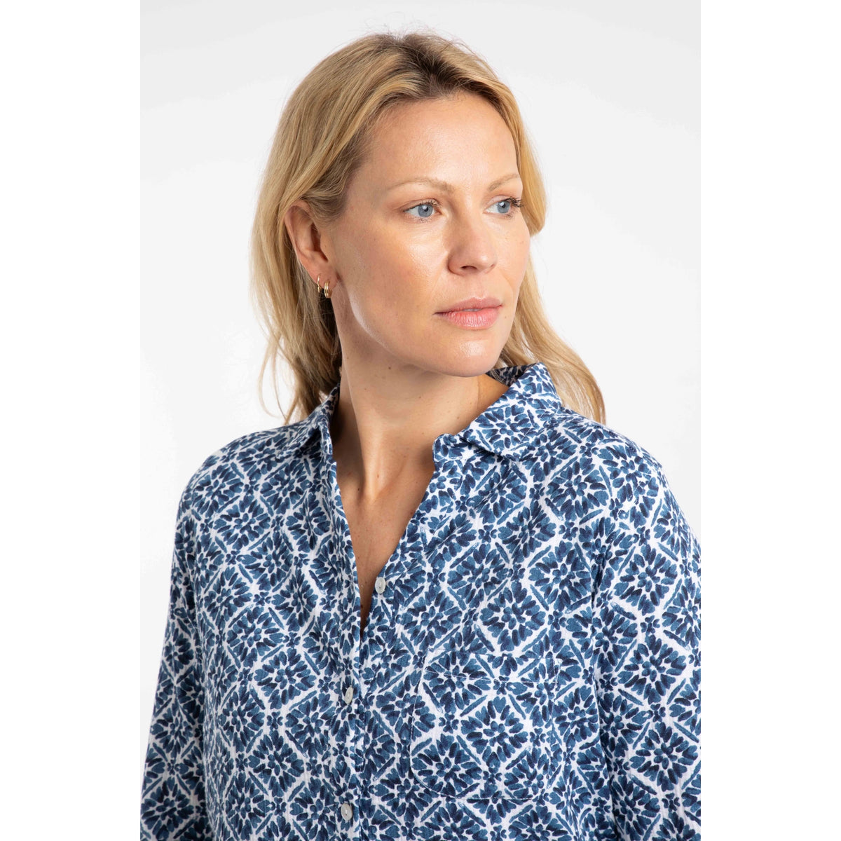 Woman wearing a Weird Fish Syona blue and white tile print shirt on a white background