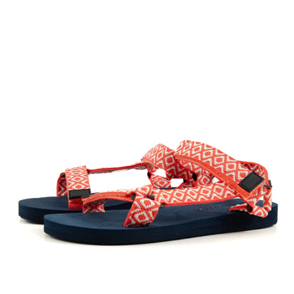 A pair of womens Weird Fish Trek webbing velcro strap sandals in coral with an Aztec style pattern and navy soles.