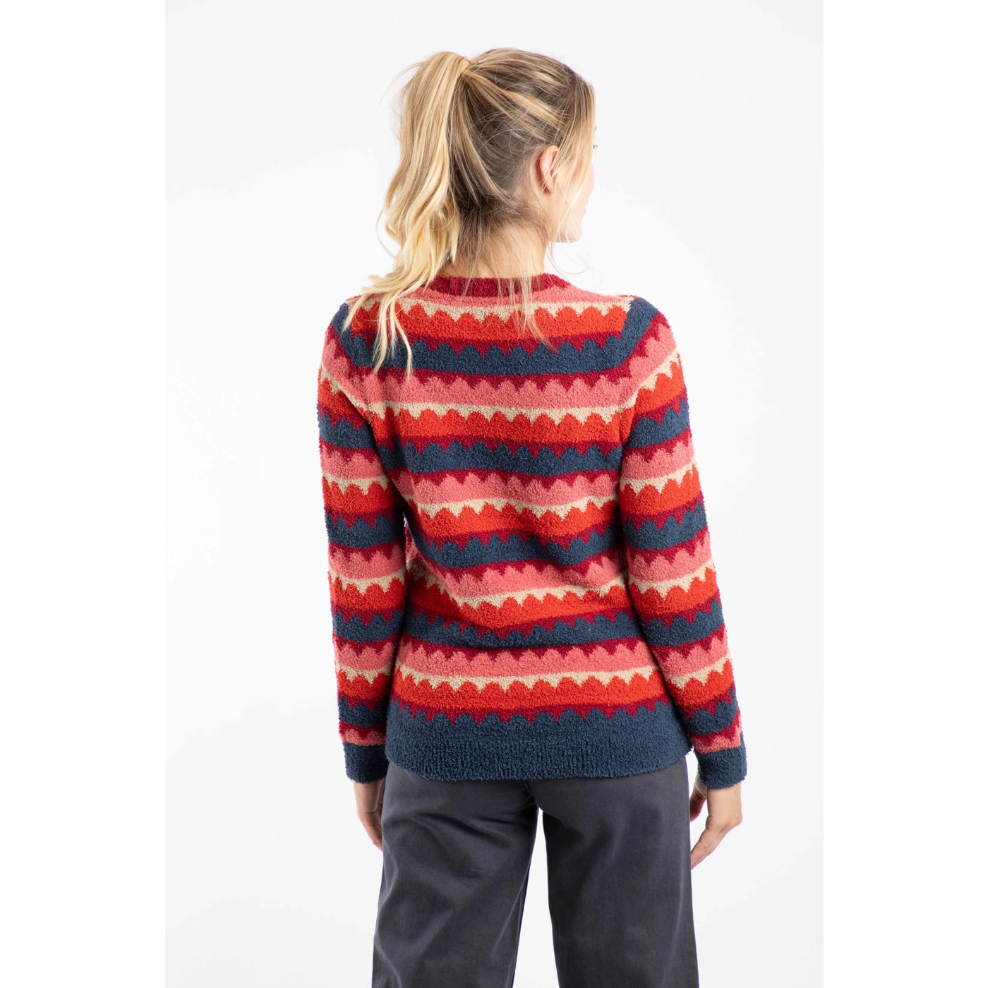 Back view of a woman wearing a Weird Fish Antique Cherry Red Tyla jumper with scalloped stripe pattern on a white background