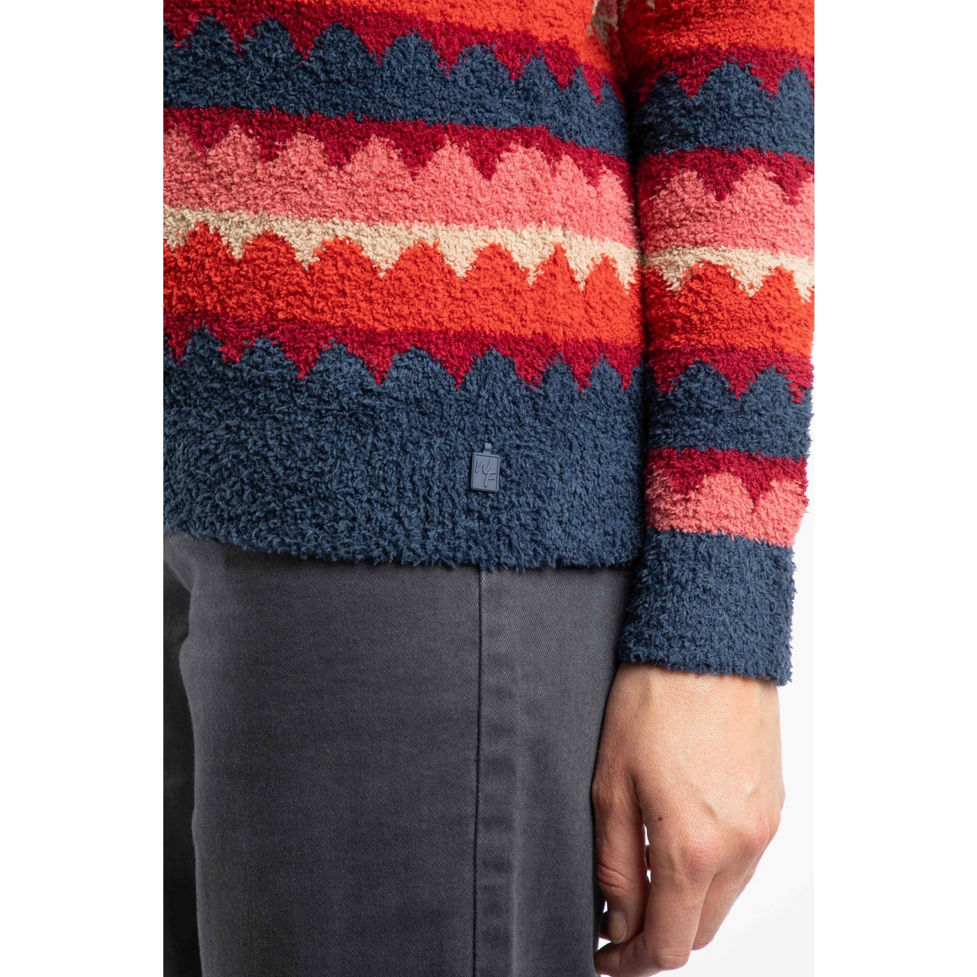 Close up of a womens Weird Fish Tyla jumper cuff in Antique Red and multicolour scallop stripe on a white background