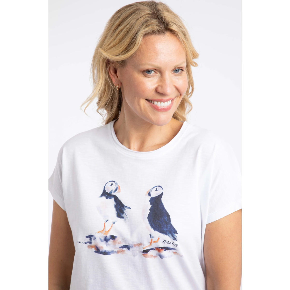 Close-up view of a woman wearing a Weird Fish white Puffin print t-shirt.