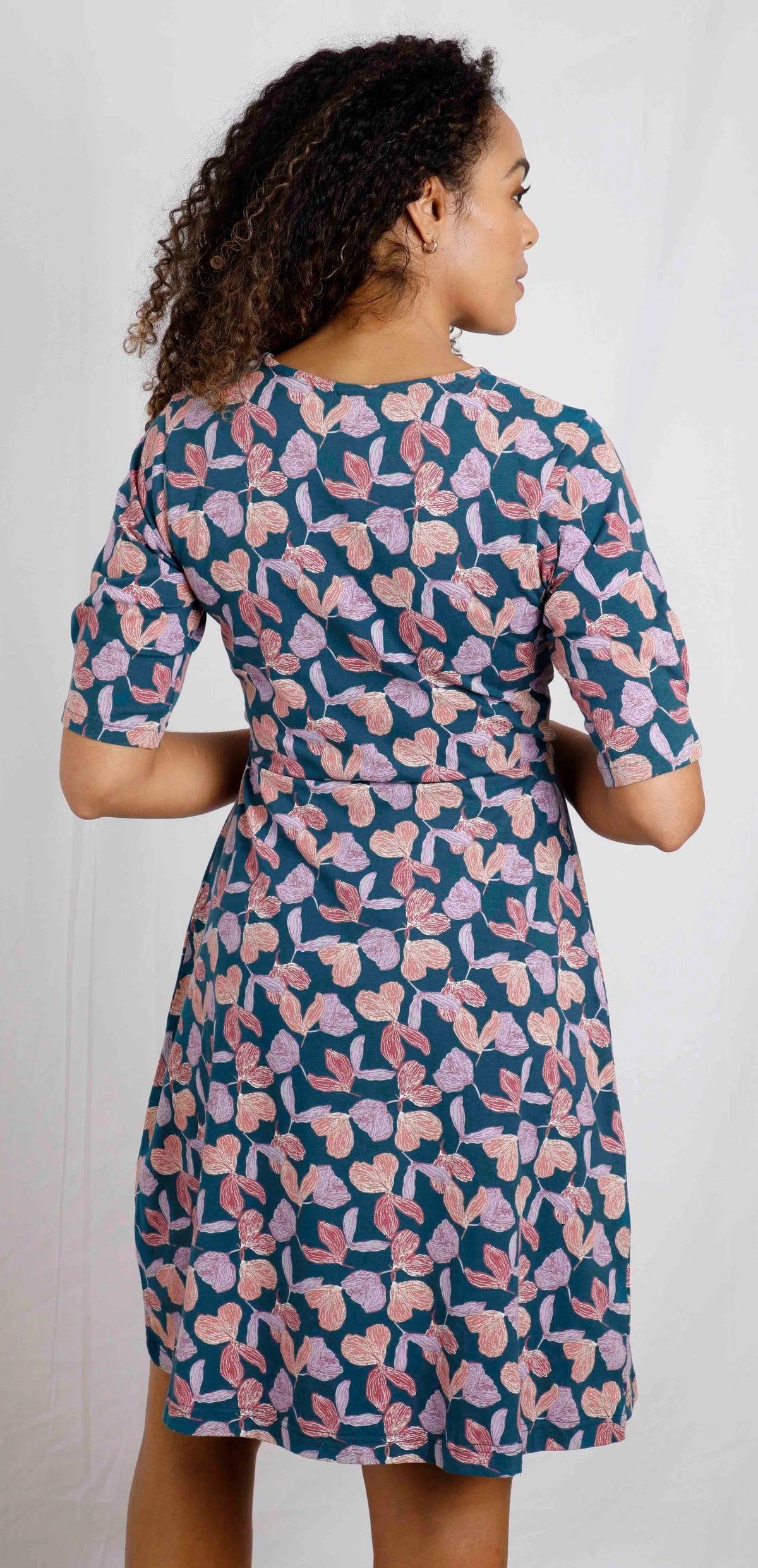 Women's half length sleeve Cassandra swing dress from Weird Fish in Deep Sea Blue with a purple floral pattern.