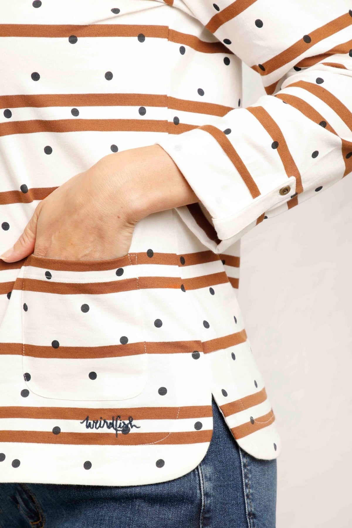 A long sleeve women's Billie tee from Weird Fish in light cream with a stripe and dotty pattern, with a crew neckline and roll up sleeves.