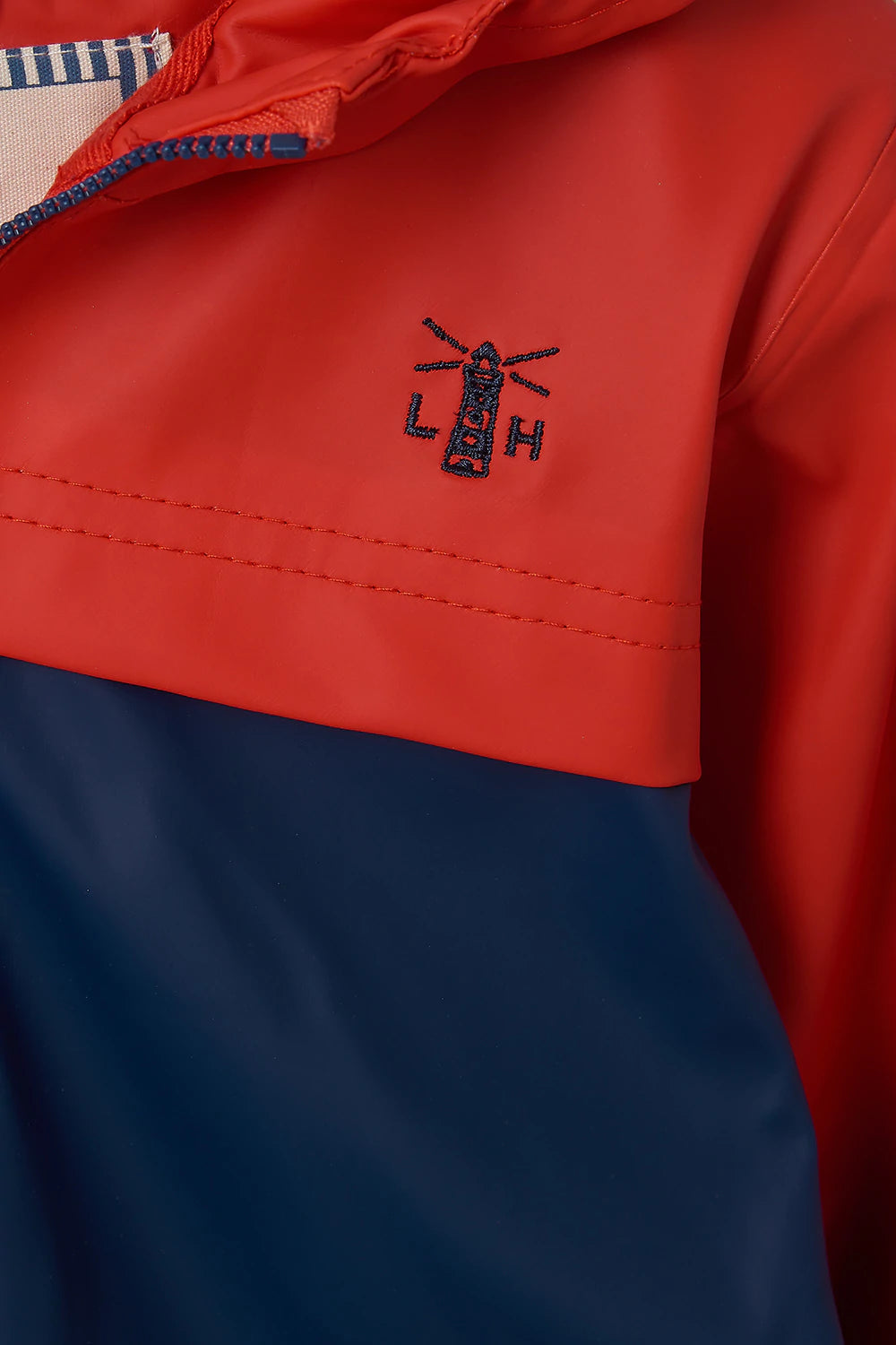 Two tone red and navy kids polyurethane waterproof Adam rain jacket fromm Lighthouse.