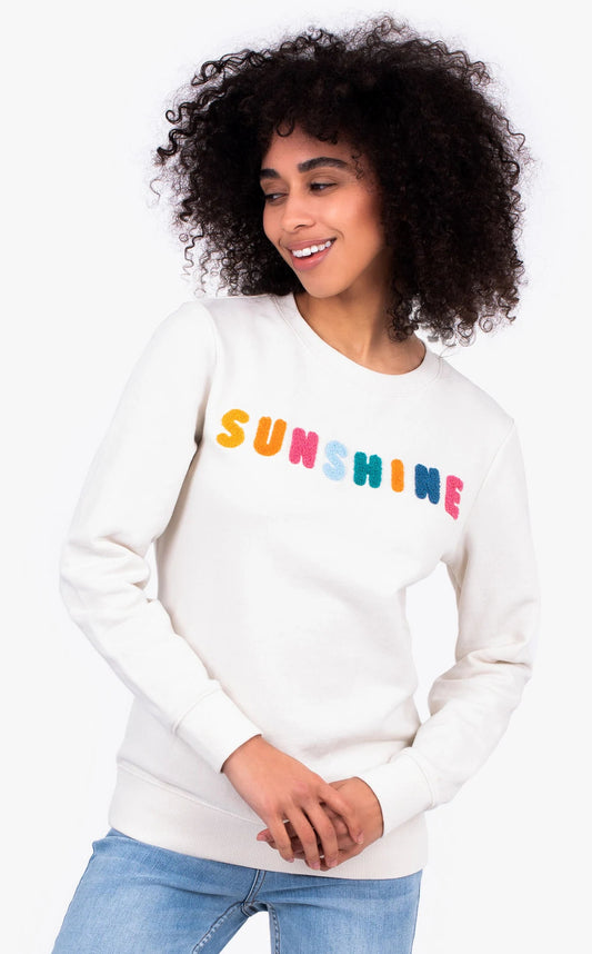 Brakeburn women's Sunshine sweater in cream with a multicoloured Sunshine letter applique sewn on the front.