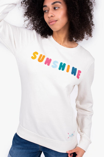 A women's cream sweatshirt from Brakeburn with multicoloured Sunshine applique letters sewn on the front in a towelling texture.