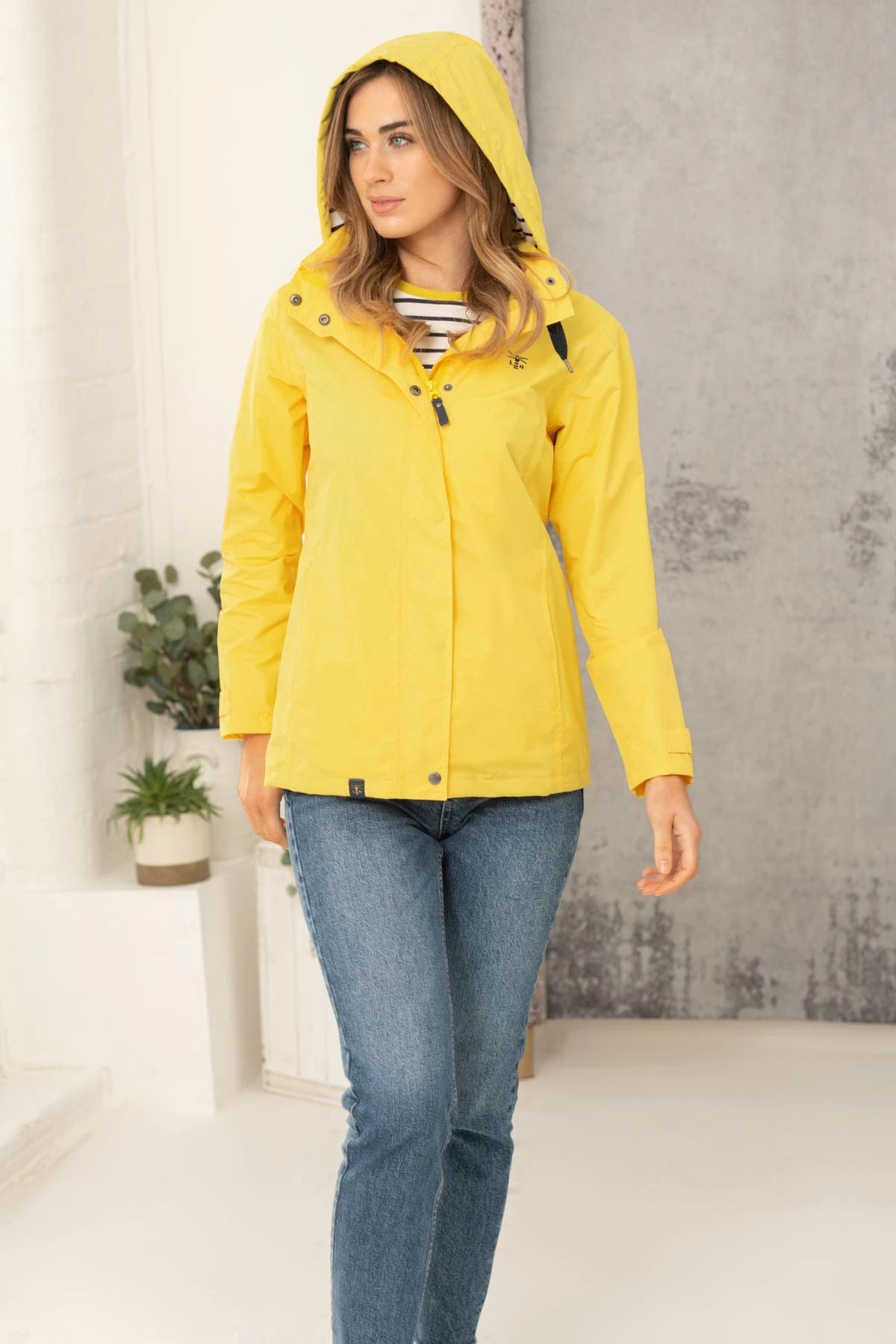 Lighthouse womens jacket yellow with hood and button closure worn with jeans indoors