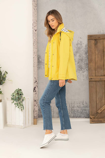 Lighthouse womens jacket yellow styled with blue jeans and white sneakers on a standing model